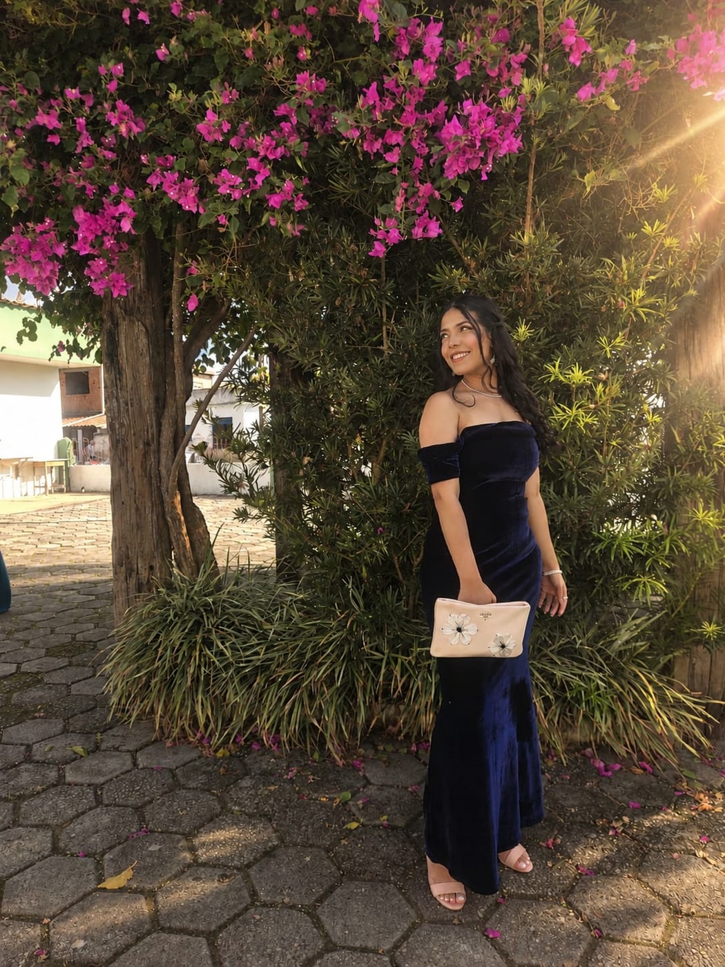 Ana Flávia, que faz os buquês da Fora da Caixa, sorrindo embaixo de uma buganvília florida