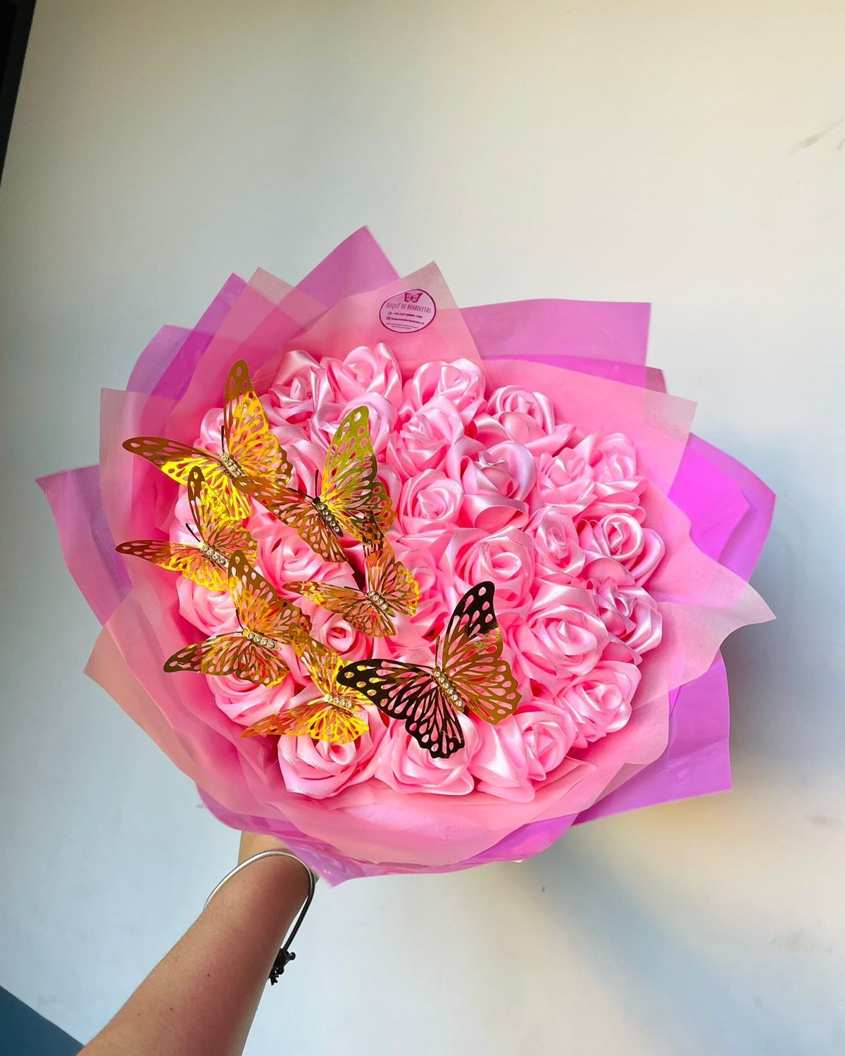 Buquê de rosas eternas cor-de-rosa com borboletas douradas, feito pela Ana Flávia